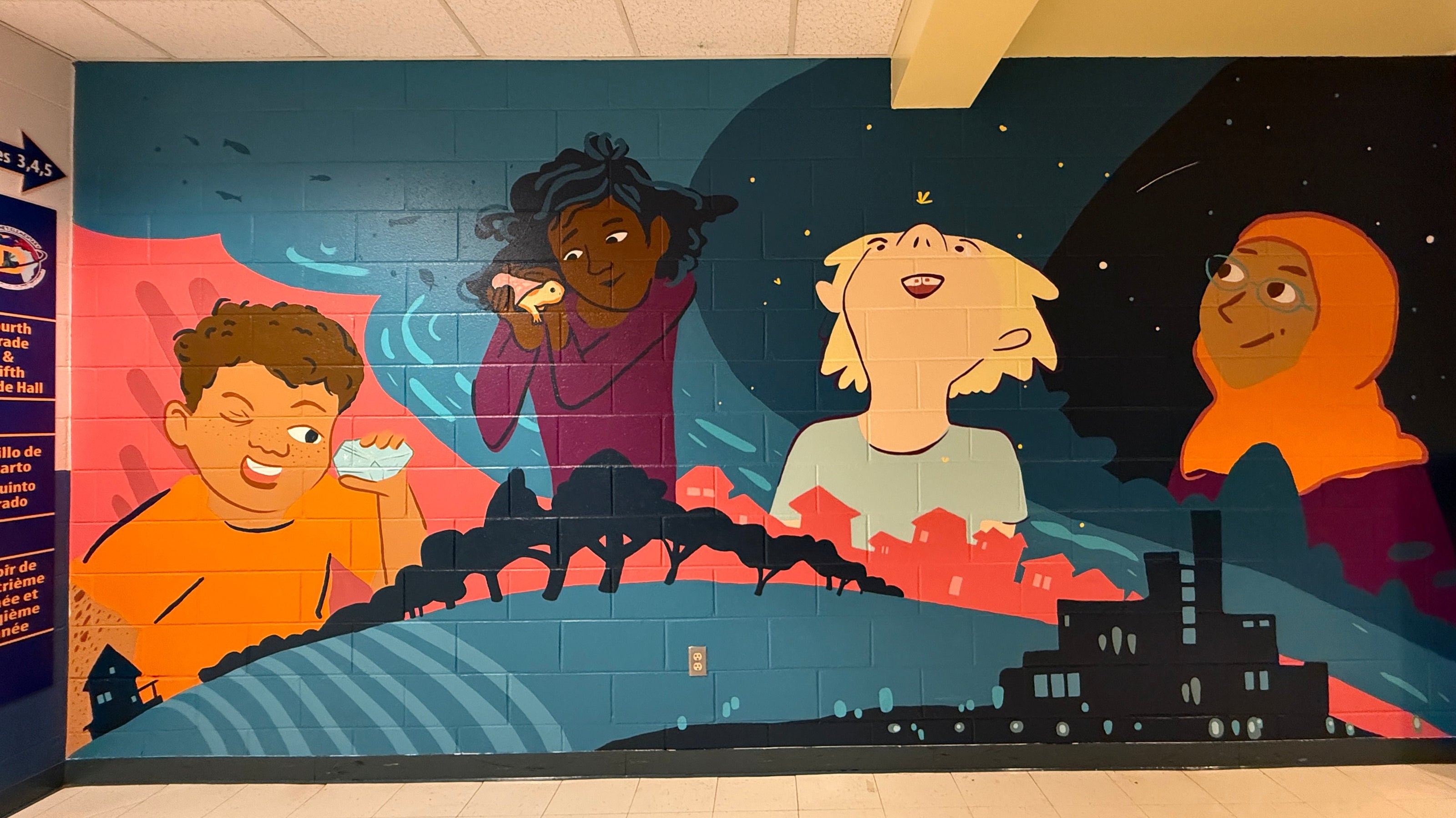 Mural of four children in a classroom setting with a cityscape background.