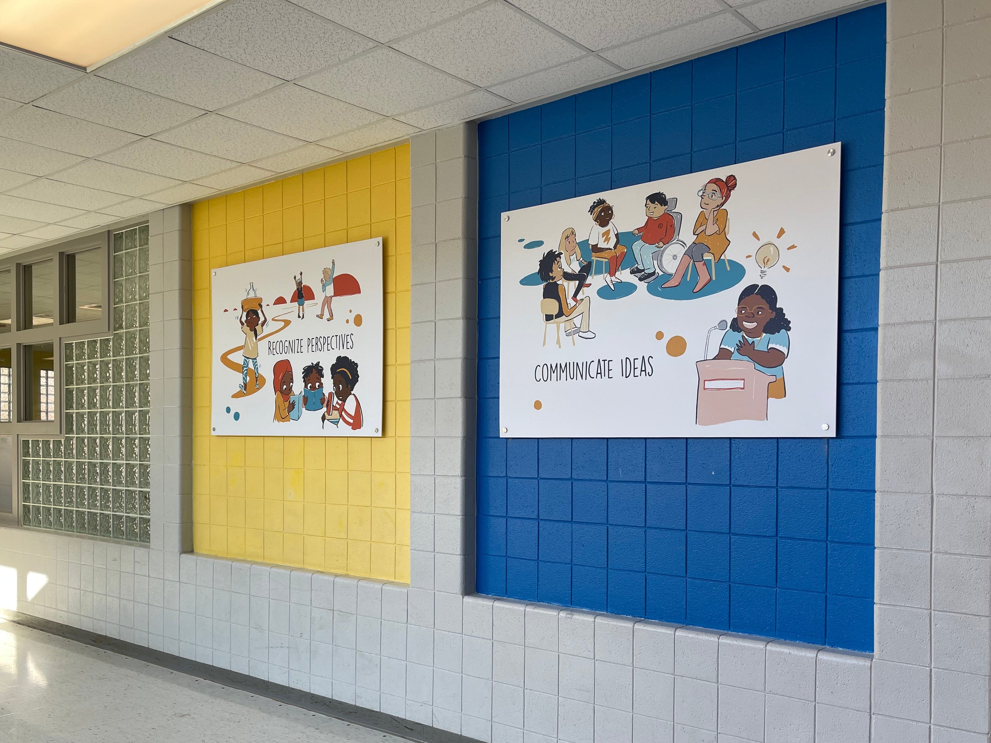 Educational posters on a tiled wall in a school hallway